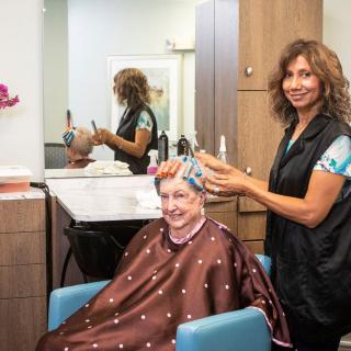 A woman at a hair salon getting her hair styled by a hairstylist.