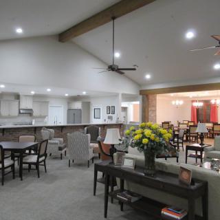 A spacious open-concept living area with a modern kitchen, dining tables, and comfortable seating.