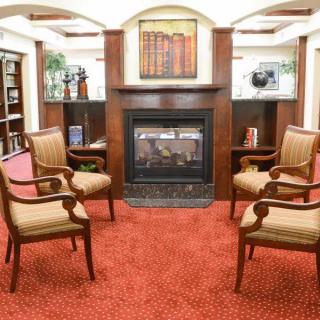 Elegant seating area with a central fireplace and classic wooden chairs.