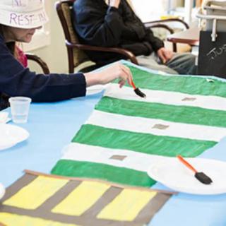 People participating in a painting activity during an art class.