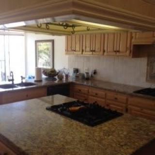 A spacious kitchen with wooden cabinets and a large countertop.