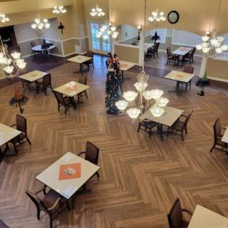 A spacious dining area with neatly arranged tables and elegant chandeliers.