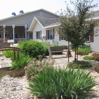 A beautifully landscaped garden with lush greenery in front of a house.