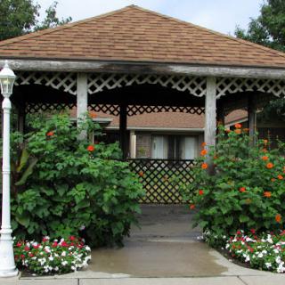 A charming gazebo surrounded by lush greenery and colorful flowers.