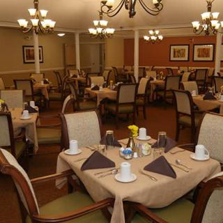 A well-arranged dining room with neatly set tables and elegant chandeliers.