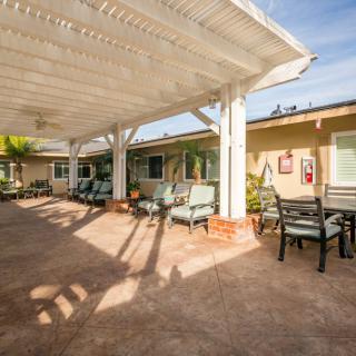 A spacious patio area with comfortable seating under a large pergola, perfect for relaxation.