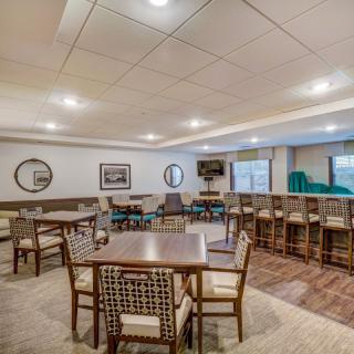 A spacious conference room with multiple tables and chairs arranged for meetings.
