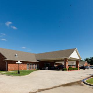 A well-maintained commercial building with a parking area under a clear blue sky.