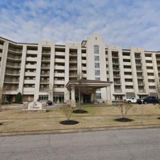 A multi-story residential apartment building with a central entrance and multiple balconies.