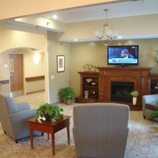 A cozy living room featuring comfortable seating, a television, and decorative plants.