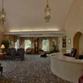 A cozy lobby with a reception desk, seating area, and elegant lighting.