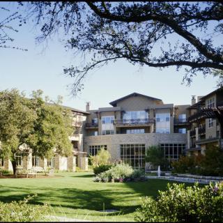 A building surrounded by trees and a well-kept lawn.