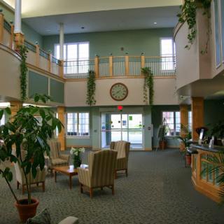 A spacious and inviting lobby with comfortable seating, plants, and ample natural light.