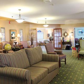 A cozy living room with sofas, lamps, and a carpeted floor.