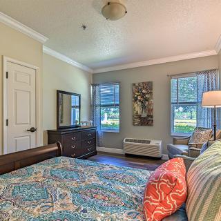 A cozy bedroom with colorful decor and ample natural light through large windows.