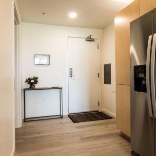 A modern, minimalist entryway with a sleek door, small table, and decor accents.