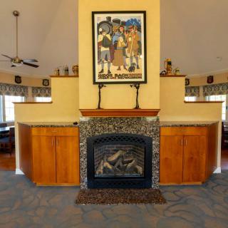 A modern living room interior featuring a fireplace surrounded by wooden cabinetry and decorated with artwork above.