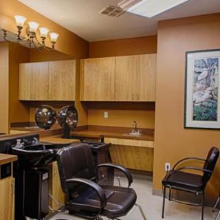 An interior view of a hair salon with chairs, sinks, and wooden cabinets.