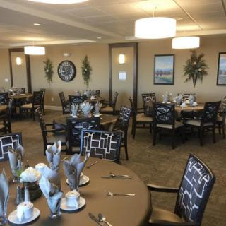A spacious and elegantly designed dining area featuring well-set tables and stylish chairs.