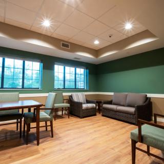 A cozy living room with comfortable seating and ample lighting.