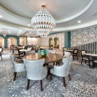 Elegant dining area with modern decor and a striking chandelier.