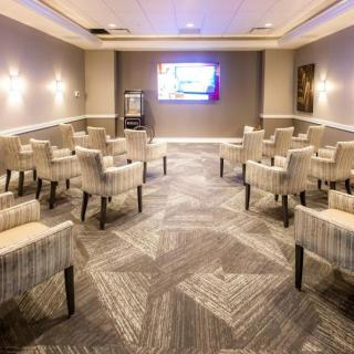 A modern conference room equipped with comfortable seating and a presentation screen.