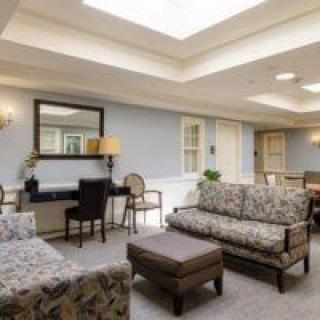 A cozy living room with sofas, chairs, and a skylight providing natural light.