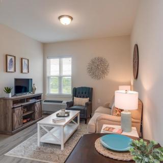 A cozy and well-decorated living room featuring a sofa, coffee table, and TV stand.
