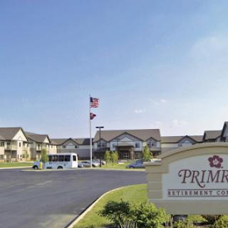 A view of a residential community featuring a prominent sign, flag, and well-maintained outdoor area.