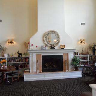 A cozy living room featuring a fireplace with decorative shelves on either side and a large mirror above.