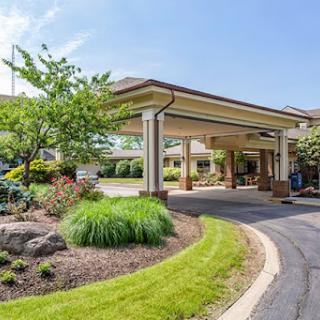 A welcoming hotel entrance surrounded by lush landscaping and a smooth driveway.