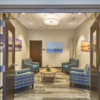 A cozy waiting room with patterned chairs and soothing artwork on the walls.