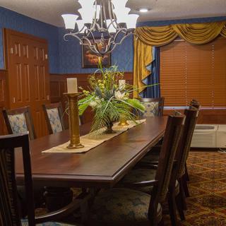 A well-decorated dining room with a large wooden table, chairs, and a chandelier.