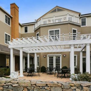 A residential building with a spacious outdoor patio and pergola.