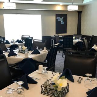 A well-arranged dining area with elegantly set tables and chairs, ready for guests.