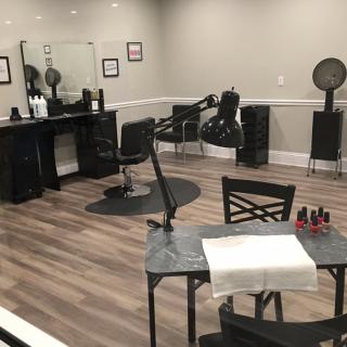 An empty hair salon with styling stations and equipment.