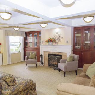 A cozy living room with a fireplace, comfortable seating, and elegant decor.