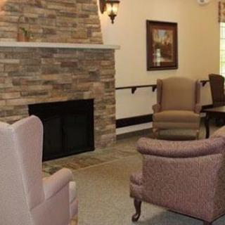A cozy living room interior featuring a stone fireplace and comfortable seating.