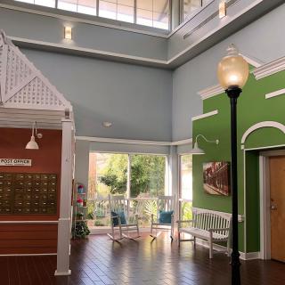A modern and spacious lobby with high ceilings, ample natural light, and a decorative streetlamp-style light fixture.