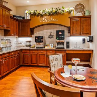 A cozy kitchen bistro with warm wooden cabinets and a small seating area.