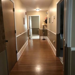 A well-lit hallway with wooden floors and warm lighting.