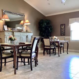 A cozy dining area featuring elegant furniture, soft lighting, and a touch of greenery.