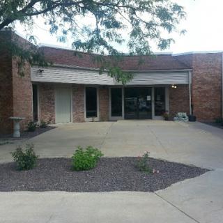 A view of a modern commercial building with a landscaped entrance.
