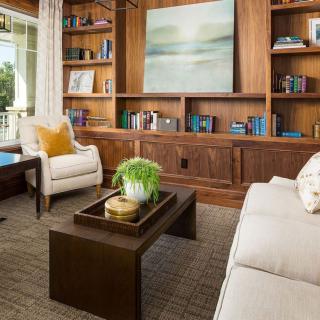 A cozy living room with a modern design featuring wooden bookshelves, a comfortable sofa, and stylish decor.