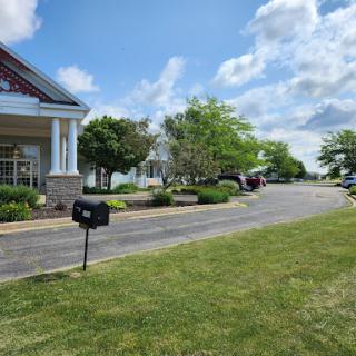 A peaceful residential area with well-maintained lawns and a clear sky.