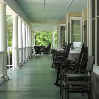 A long, inviting porch with rocking chairs and columns, offering a serene outdoor space.