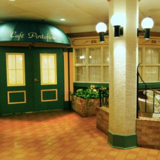 A cozy indoor cafe entrance with green doors and warm lighting.