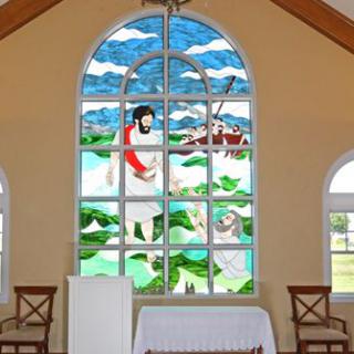 A stained glass window depicting a religious scene in a church interior.
