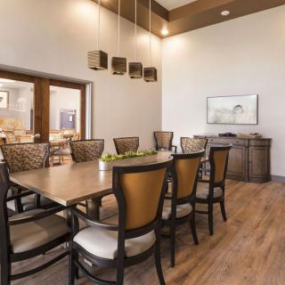 A modern dining room with a large table and pendant lighting.