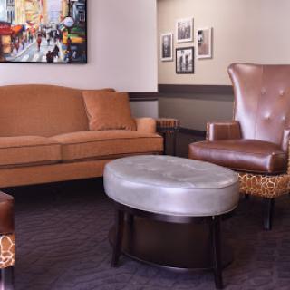 A cozy living room setup featuring a comfortable sofa, stylish armchairs, and a decorative ottoman.